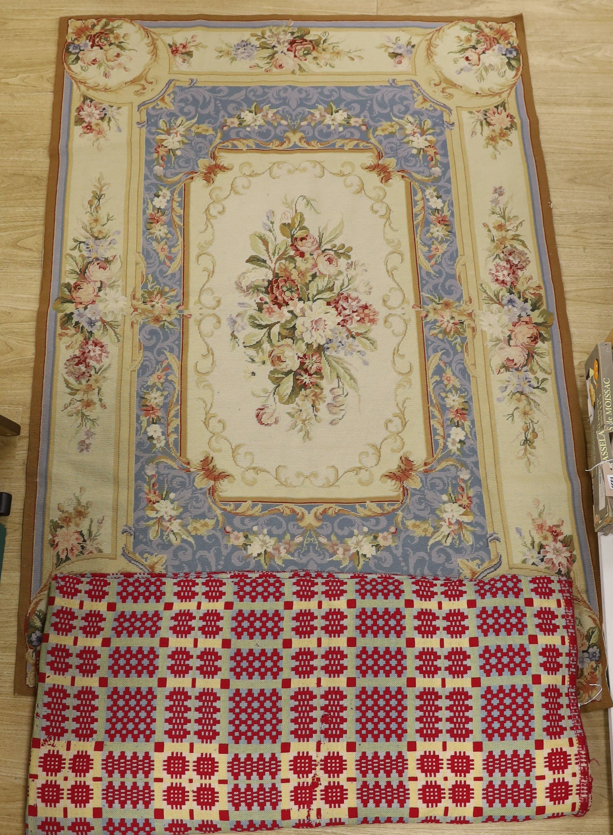 A 20th century wool worked floral rug and a woven Welsh blanket